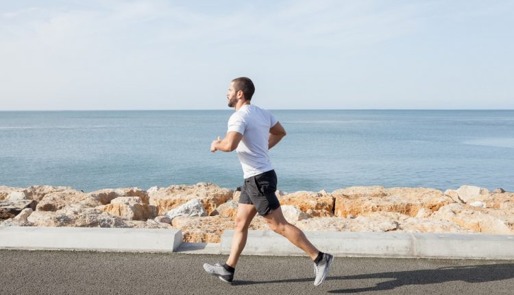 young-strong-sporty-man-running-road-along-sea-1