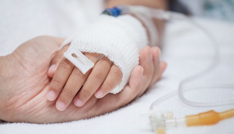 Mother hand holding child hand who have IV solution in the hospi