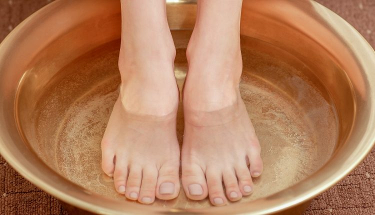 Female feet care in bowl.