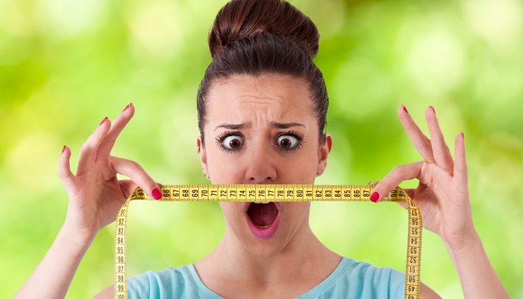 woman with tape measure worried about weight