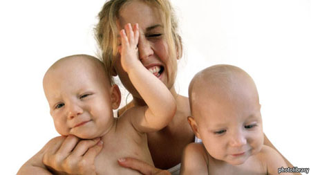 Close-up of a mother holding her two baby boys