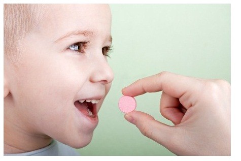 Human hand giving child medicine healthcare pill