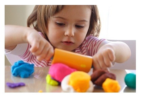 Little girl creating toys from play dough