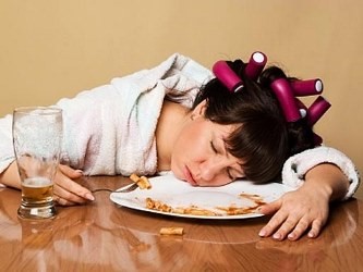 Young woman fell asleep at the table after hard eating.