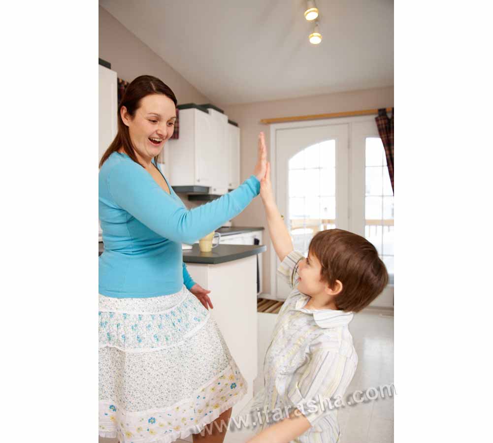 Mother and son giving high five at home