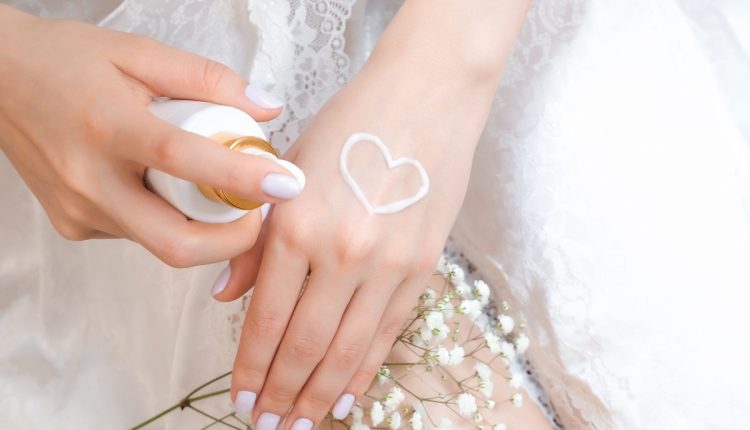 young woman applies hand cream from a tube of cream.