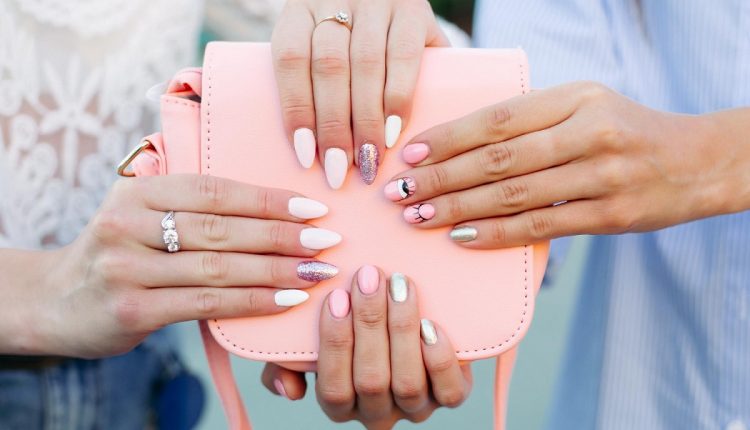 two-girls-with-design-manicure-holding-leather-pink-bag